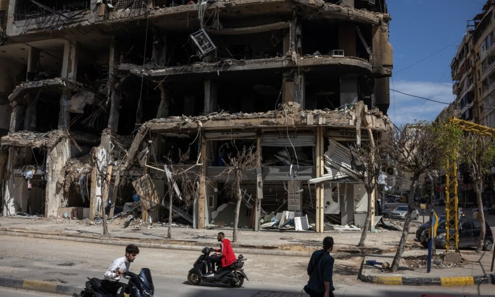 Personas pasan por edificios dañados en Beirut durante un alto el fuego de 10 días entre Líbano e Israel [Marko Djurica/Reuters]