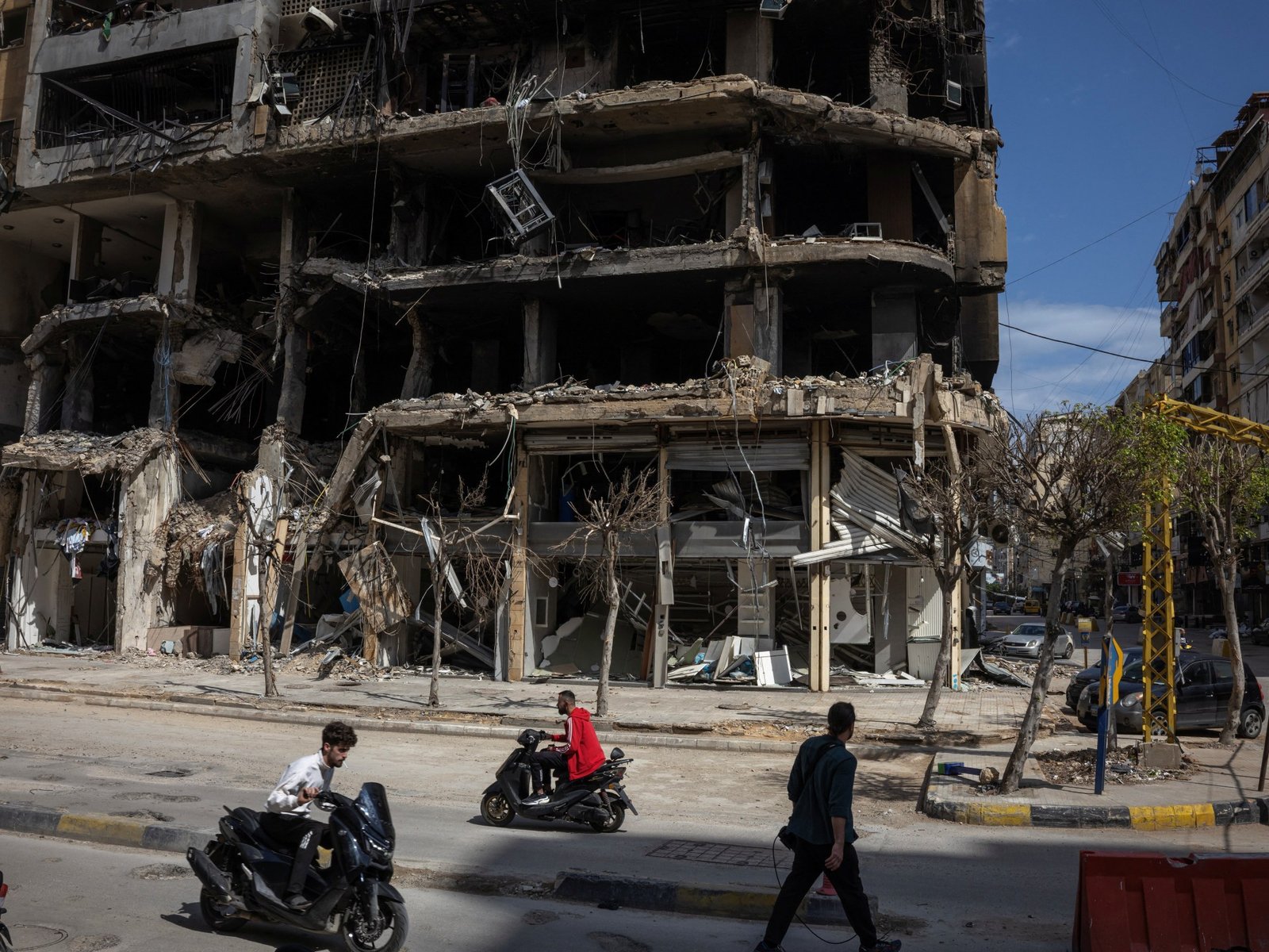 Personas pasan por edificios dañados en Beirut durante un alto el fuego de 10 días entre Líbano e Israel [Marko Djurica/Reuters]