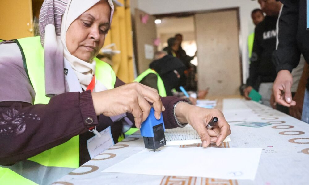 Un oficial electoral palestino registra votantes antes de que estos emitan su voto en una estación electoral durante las elecciones municipales en Deir el-Balah [AFP]