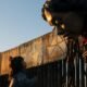 Una niña se acerca a la Pequeña Amal, una marioneta de casi cuatro metros de altura que representa a una niña refugiada siria de diez años, cerca del muro fronterizo entre Estados Unidos y México, en Tijuana. Imagen: GUILLERMO ARIAS/AFP