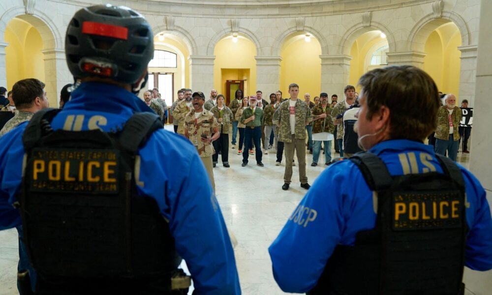 Oficiales de la Policía del Capitólio de los EE. UU. observan mientras veteranos, miembros de familias militares y simpatizantes ocupan el edificio Cannon House Office en Capitol Hill exigiendo que la administración Trump ponga fin a la guerra contra Irán en Washington, DC [Leigh Vogel/Getty Images via AFP]