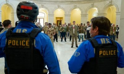 Oficiales de la Policía del Capitólio de los EE. UU. observan mientras veteranos, miembros de familias militares y simpatizantes ocupan el edificio Cannon House Office en Capitol Hill exigiendo que la administración Trump ponga fin a la guerra contra Irán en Washington, DC [Leigh Vogel/Getty Images via AFP]