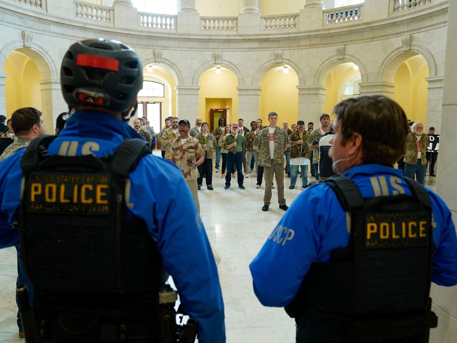 Oficiales de la Policía del Capitólio de los EE. UU. observan mientras veteranos, miembros de familias militares y simpatizantes ocupan el edificio Cannon House Office en Capitol Hill exigiendo que la administración Trump ponga fin a la guerra contra Irán en Washington, DC [Leigh Vogel/Getty Images via AFP]