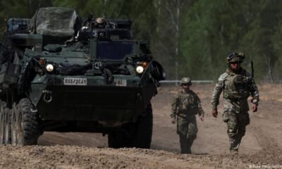 retiro prolongado tropas — Soldados estadounidenses caminan junto a un vehículo militar en un camino de tierra, en Polonia. Foto de: Kuba Stezycki/REUTERS