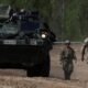 tropas Polonia — Soldados del Ejército de los EE. UU. marchan en formación durante el ejercicio Sword 26, acercándose a un vehículo MEDEVAC mientras las fuerzas de la OTAN demuestran innovaciones en la evacuación de bajas en el campo de batalla utilizando drones y tecnología médica en Bemowo Piskie, Polonia, el 11 de mayo de 2026. Tomada por: © Kuba Stezycki/REUTERS