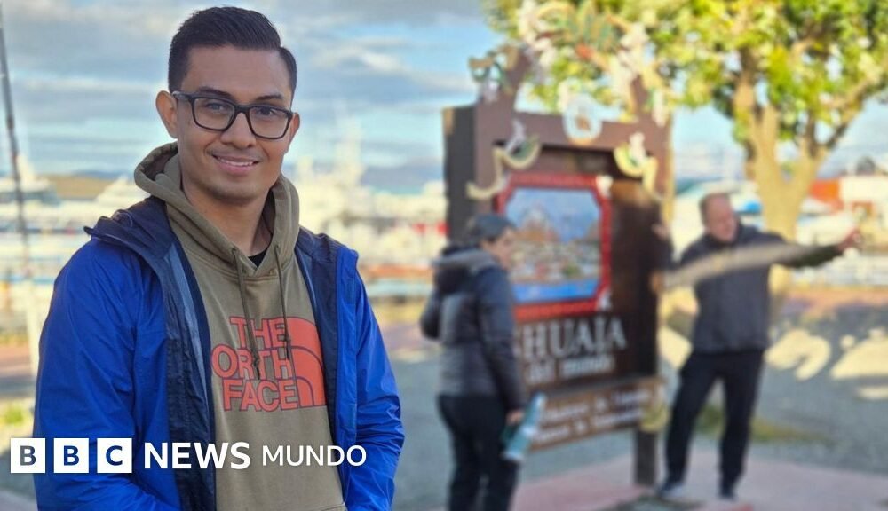 Crucero Hondius llega — Hombre sonríe a la cámara mientras dos personas detrás de él se toman una foto