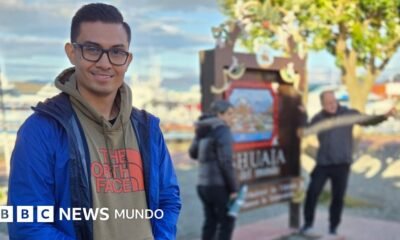 Crucero Hondius llega — Hombre sonríe a la cámara mientras dos personas detrás de él se toman una foto