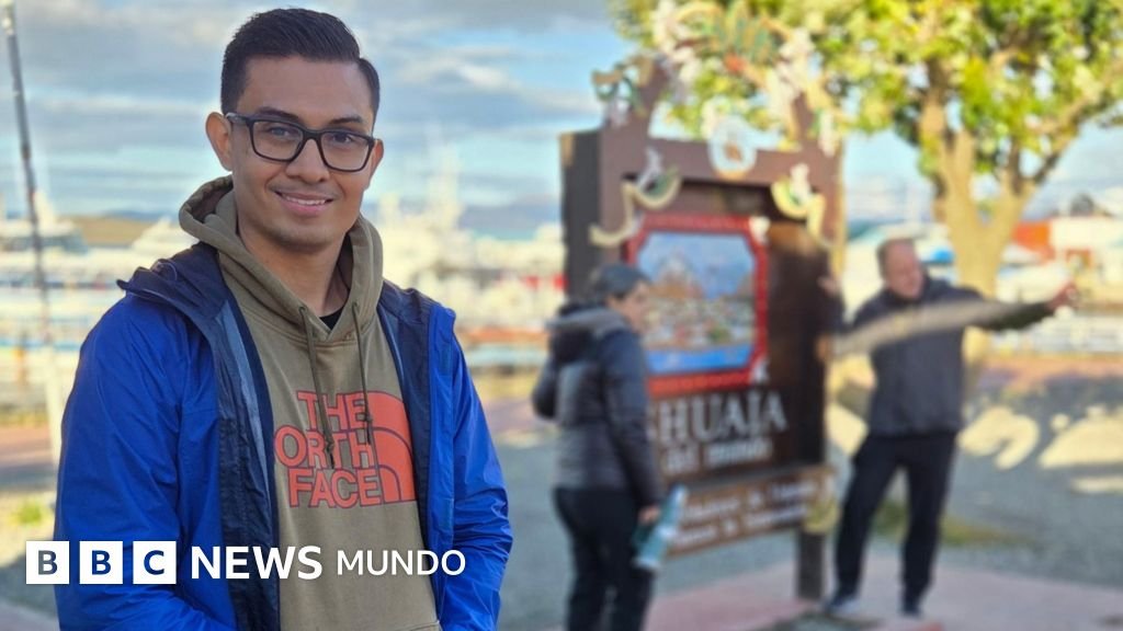Crucero Hondius llega — Hombre sonríe a la cámara mientras dos personas detrás de él se toman una foto