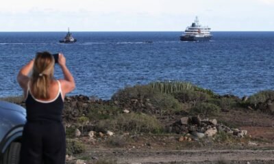 Finaliza evacuación Hondius — Una mujer fotografía la salida del crucero 'Hondius' en el puerto de Granadilla de Abona, en Tenerife, España, el 11 de mayo. Hannah McKay (REUTERS)