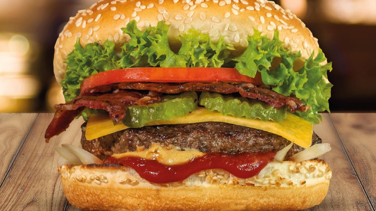 Five Guys — Una hamburguesa con aderezo de tomate y queso, lista para ser disfrutada. Foto de: Marca