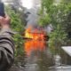 minería ilegal — Una persona toma una fotografía de un gran incendio que arde en la vegetación ribereña de un río. Foto de: La República