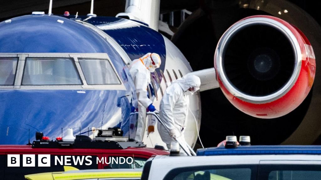 OMS advierte rastreo — Personas con ropa de protección personal descienden de un avión.