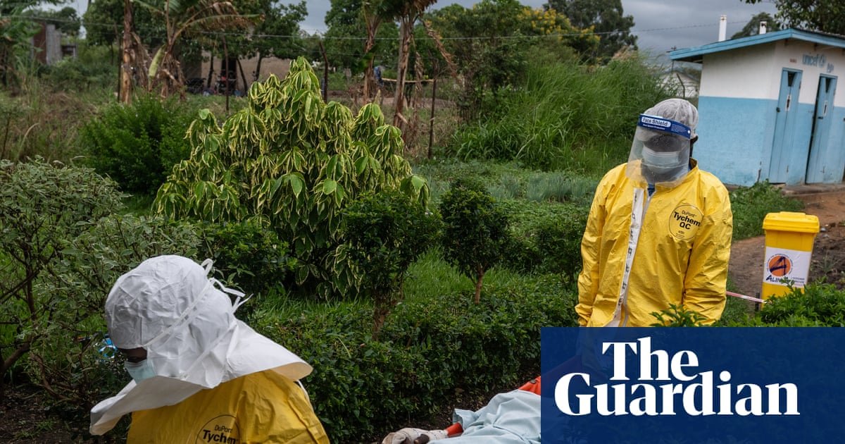 OMS eleva brote — Personal de salud en equipo de protección total maneja pacientes en un área de contención, reflejando la alerta de brote de Ébola en la República Democrática del Congo. Foto de: The Guardian