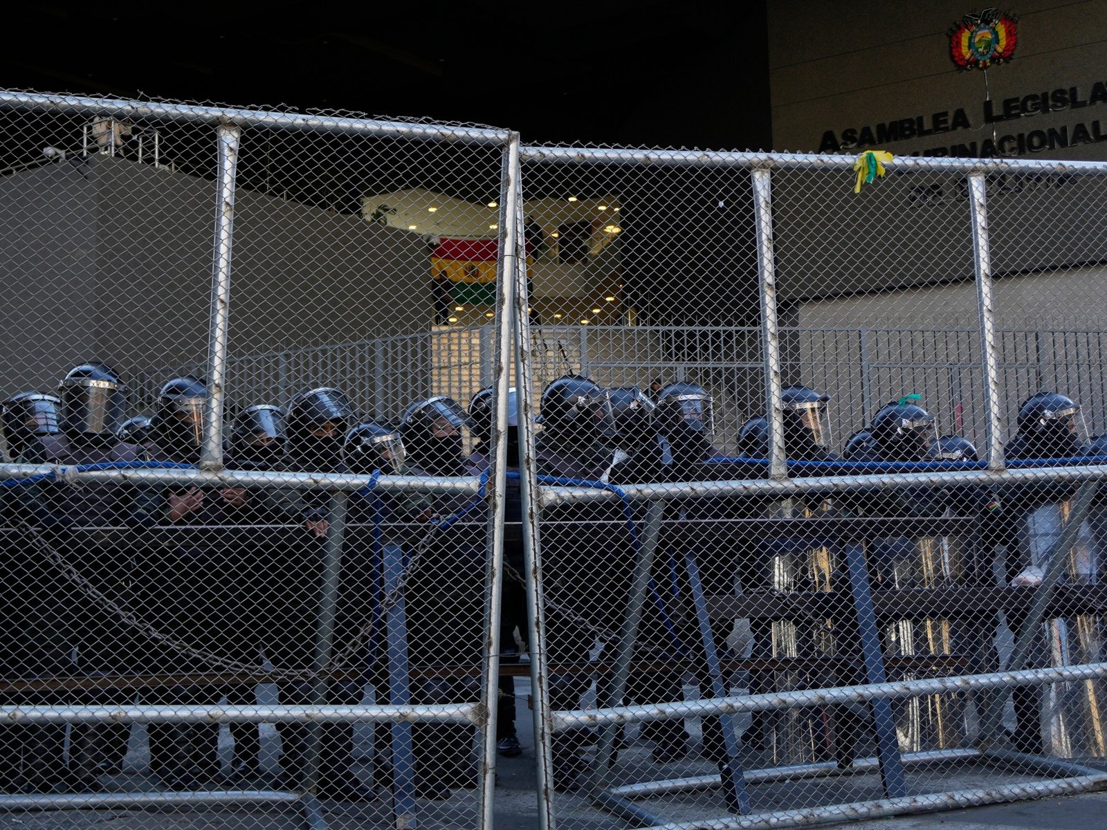 presidente Paz — La policía mantiene la guardia detrás de una valla durante las protestas anti-gobierno cerca del palacio en La Paz, Bolivia. Foto de: Juan Karita/AP Photo