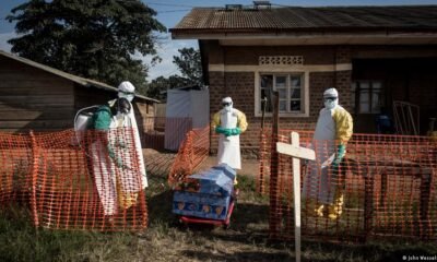 brote ébola — Funcionarios en equipo de protección personal desinfectan un ataúd en un centro de tratamiento para pacientes con ébola en la RDC. Foto de: Imagen: John Wessels/AFP