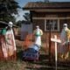brote ébola — Funcionarios en equipo de protección personal desinfectan un ataúd en un centro de tratamiento para pacientes con ébola en la RDC. Foto de: Imagen: John Wessels/AFP