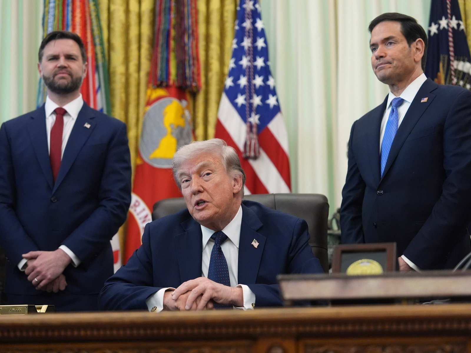 Trump pausa escolta — El presidente Donald Trump habla mientras el secretario de Estado Marco Rubio, a la derecha, y el vicepresidente JD Vance escuchan en la Casa Blanca, el 23 de abril de 2026, en Washington, DC, EE. UU. [Mark Schiefelbein/AP Photo]