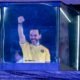 estrecha ventaja — El futbolista Sergio Agüero celebra con el puño en alto mientras aparece dentro de una estructura transparente iluminada. Foto de: news.google.com