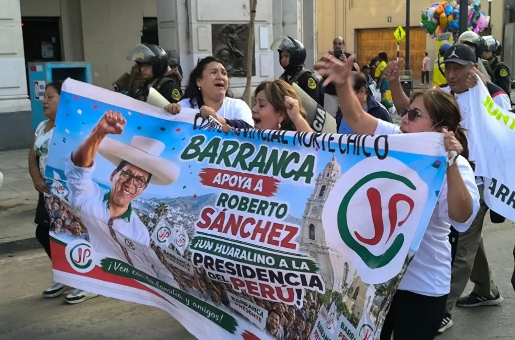 protestas voto popular — Varias personas sostienen una gran pancarta con el rostro de un hombre con sombrero y el nombre de Roberto Sánchez. Foto de: news.google.com