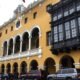 Alcaldía Metropolitana — Vista exterior de un edificio amarillo con balcones de madera oscura y una serie de arcos en la planta baja. Foto de: Gestión