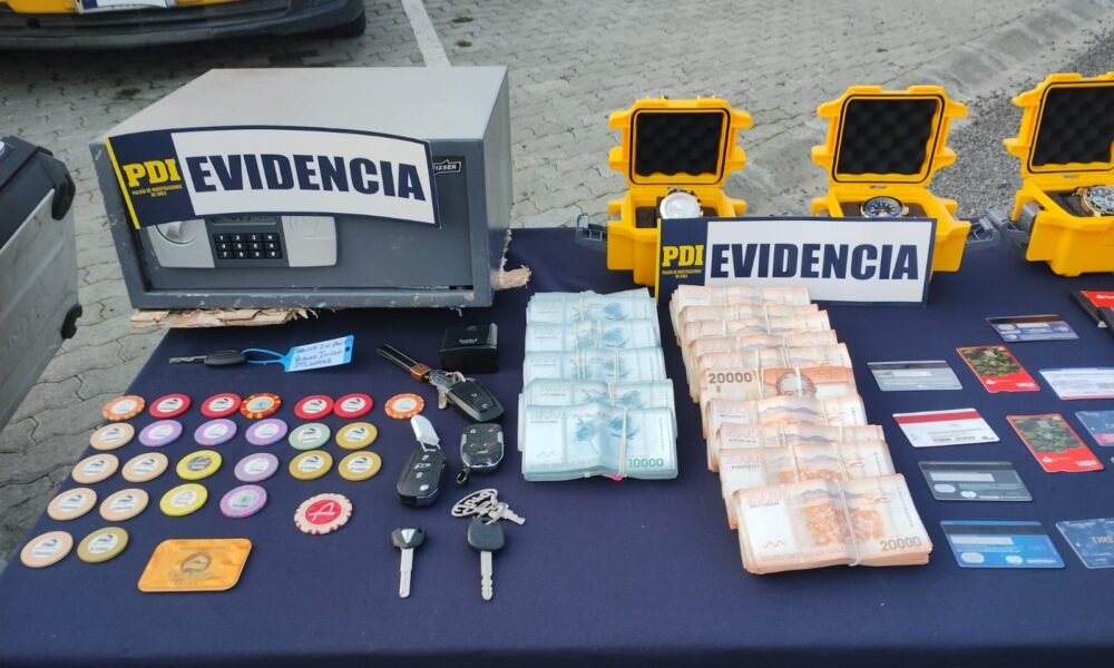 tráfico peces amenazados — Una mesa con fajos de dinero, llaves, tarjetas y diversos objetos sobre un fondo azul con carteles que dicen 'EVIDENCIA'. Foto de: Mongabay Perú