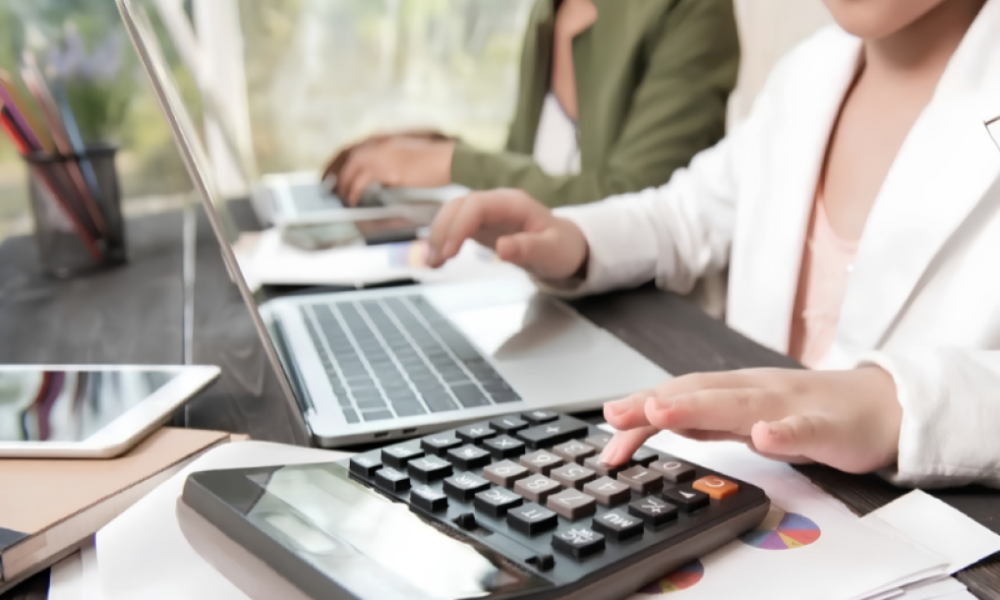 calculo pago feriado peruano — Una persona utiliza una calculadora y una computadora para realizar cálculos financieros sobre el pago de horas extra en días feriados. Foto de: Perú21