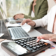 calculo pago feriado peruano — Una persona utiliza una calculadora y una computadora para realizar cálculos financieros sobre el pago de horas extra en días feriados. Foto de: Perú21