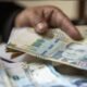 Mano sosteniendo billetes de 100 soles peruanos en un contexto de preocupación por el déficit fiscal y la economía del país. Foto de: Gestión