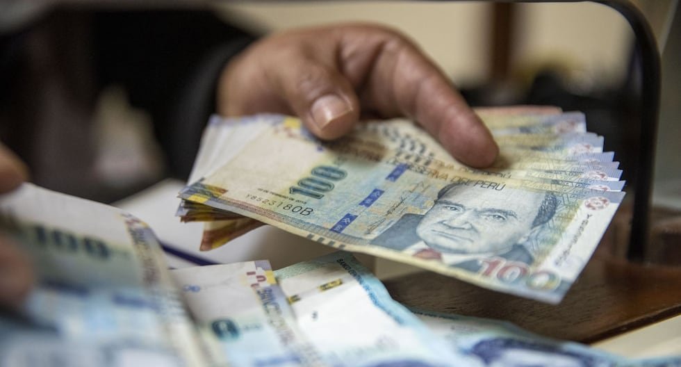 Mano sosteniendo billetes de 100 soles peruanos en un contexto de preocupación por el déficit fiscal y la economía del país. Foto de: Gestión