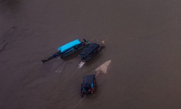 Embarcaciones operan en aguas turbias de la Amazonía peruana, evidenciando la actividad minera ilegal detectada en sobrevuelos recientes. Foto de: Santiago Romaní