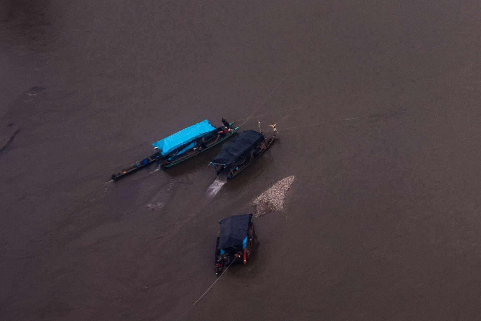 Embarcaciones operan en aguas turbias de la Amazonía peruana, evidenciando la actividad minera ilegal detectada en sobrevuelos recientes. Foto de: Santiago Romaní