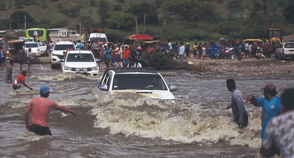 Niño riesgos trabajadores — Vehículos y personas atraviesan una zona inundada por las lluvias causadas por el fenómeno de El Niño. Foto de: Gestión