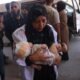 Fuerzas israelíes — Una enfermera palestina carga a un niño herido en el hospital Nasser tras los ataques israelíes contra campamentos de desplazados en la Franja de Gaza. Foto de: AFP