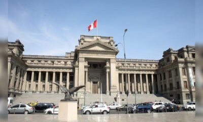 decisiones jurisdiccionales — Vista exterior del edificio del Parlamento de Canadá con la bandera nacional y vehículos estacionados frente a una estatua. Foto de: La República