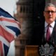 Partido Laborista — El primer ministro británico Keir Starmer habla ante una multitud mientras la bandera del Reino Unido ondea en el fondo. Foto de: Exitosa Noticias