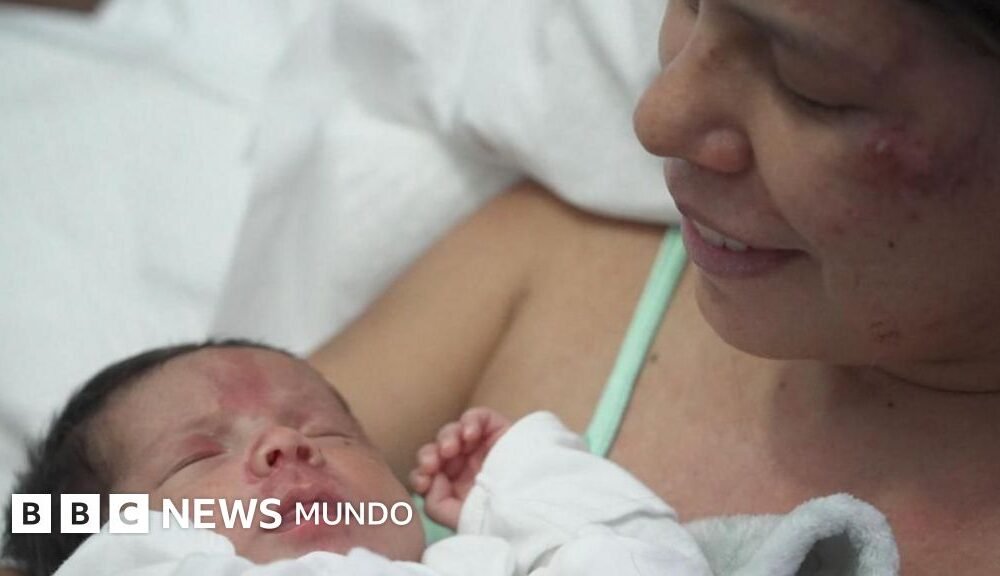 días atrapados — Una madre sostiene a su hijo de 18 días en brazos tras ser rescatada junto a él en Venezuela. Foto de: BBC Mundo