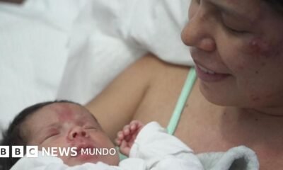 días atrapados — Una madre sostiene a su hijo de 18 días en brazos tras ser rescatada junto a él en Venezuela. Foto de: BBC Mundo