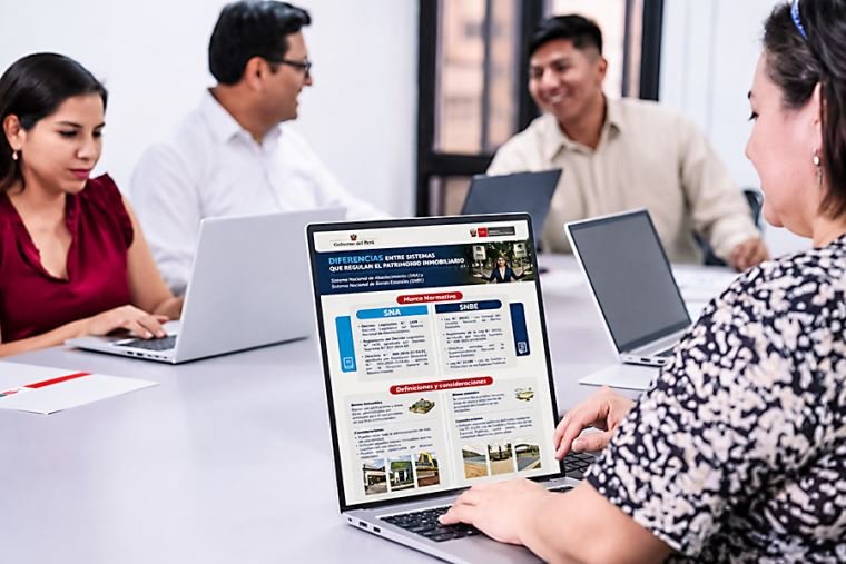 bienes inmuebles — Tres personas trabajan frente a computadoras portátiles en una mesa larga, analizando información en pantallas durante una reunión. Foto de: El Peruano