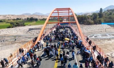 paro indefinido — Una multitud de personas camina y se agrupa sobre un puente de estructura naranja bajo un cielo despejado. Foto de: La República