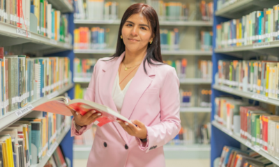 Pronabec convoca seminario — Una mujer sostiene un libro en una biblioteca, simbolizando los desafíos educativos y el crecimiento que busca promover Pronabec. Foto de: Perú21