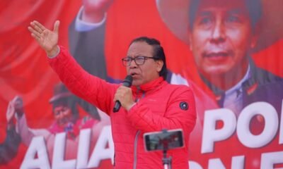 Roberto Sánchez — Un hombre con una chaqueta roja habla frente a un micrófono ante un cartel que menciona la palabra 'ALIANZA'. Foto de: news.google.com