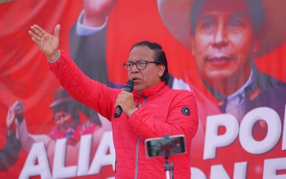 Roberto Sánchez — Un hombre con una chaqueta roja habla frente a un micrófono ante un cartel que menciona la palabra 'ALIANZA'. Foto de: news.google.com