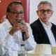 votos extranjeros Perú — Dos hombres con gafas y camisas blancas hablan frente a un micrófono en un evento con el logo de APEP. Foto de: news.google.com
