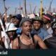 violencia xenofoba — Manifestantes en Sudáfrica portan palos y otros objetos durante una protesta que exige la deportación de inmigrantes indocumentados. Foto de: Reuters/Ihsaan Haffejee