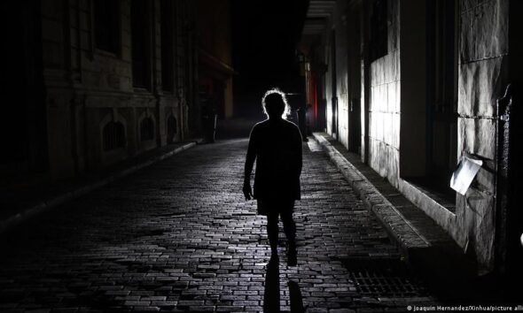 apagón Cuba eléctrico — Una mujer camina por una calle oscura en La Habana durante uno de los apagones que afectan a Cuba. Foto de: Joaquín Hernández