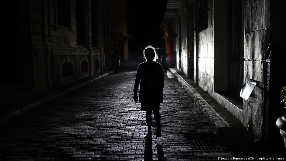 apagón Cuba eléctrico — Una mujer camina por una calle oscura en La Habana durante uno de los apagones que afectan a Cuba. Foto de: Joaquín Hernández
