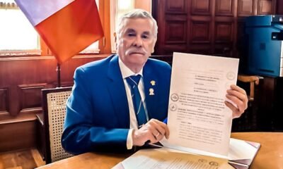 Congreso promulga ley — Un funcionario muestra un documento oficial relacionado con la nueva ley que sanciona a policías y militares por colaborar con criminales. Foto de: El Peruano