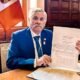 Congreso promulga ley — Un funcionario muestra un documento oficial relacionado con la nueva ley que sanciona a policías y militares por colaborar con criminales. Foto de: El Peruano
