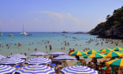 ola calor España — Bañistas disfrutan de las aguas del mar en una playa con sombrillas durante la ola de calor en España. Foto de: Pixabay