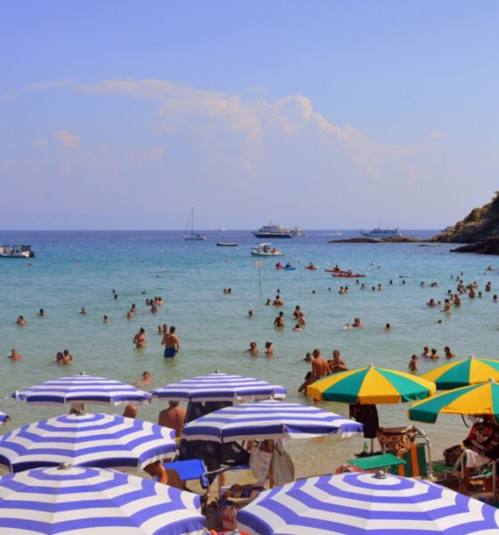 ola calor España — Bañistas disfrutan de las aguas del mar en una playa con sombrillas durante la ola de calor en España. Foto de: Pixabay